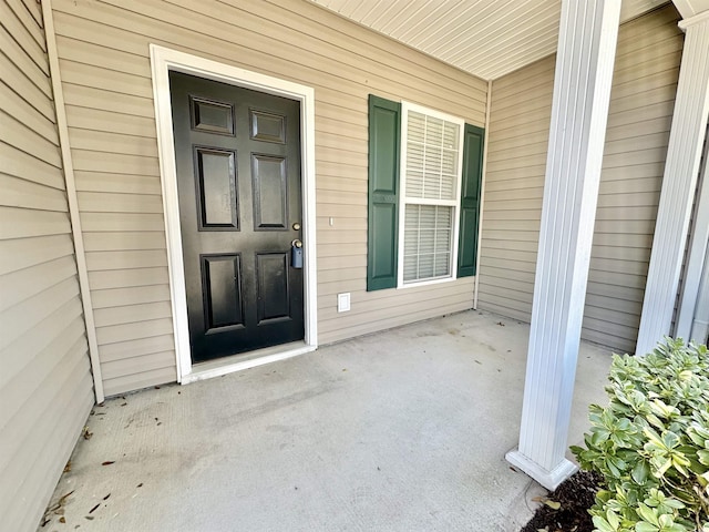 view of exterior entry featuring covered porch