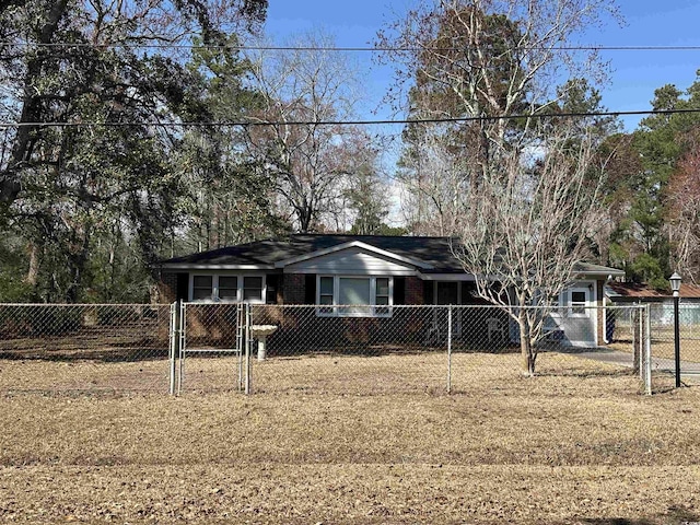 ranch-style house with a gate, brick siding, and a fenced front yard