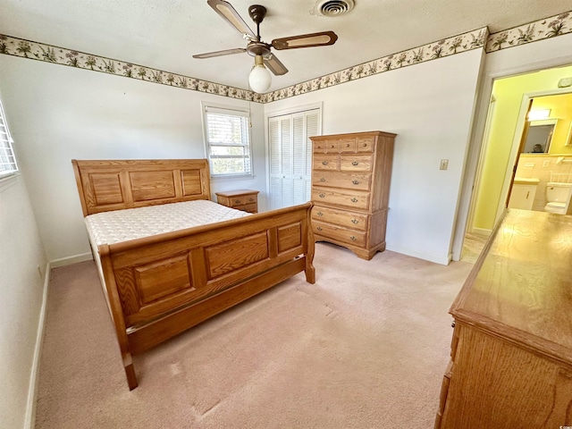 bedroom with baseboards, visible vents, ceiling fan, a closet, and light carpet