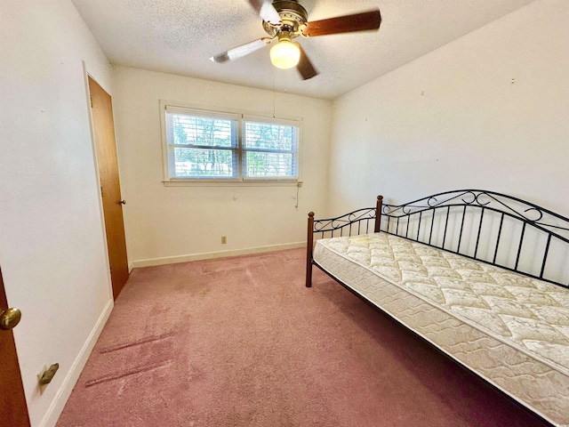 bedroom featuring a ceiling fan, light colored carpet, baseboards, and a textured ceiling