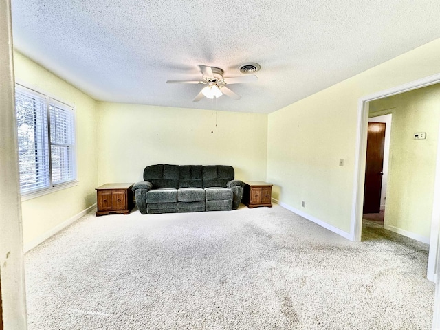 living area with visible vents, carpet flooring, baseboards, and a ceiling fan