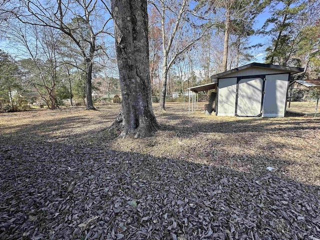 view of yard featuring an outbuilding, a carport, and a shed