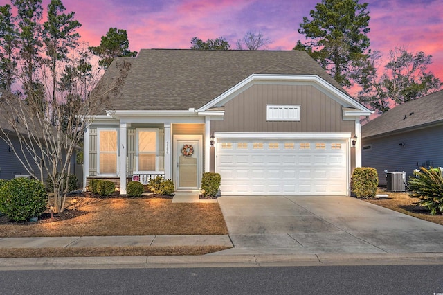 view of front of home with cooling unit, driveway, and an attached garage