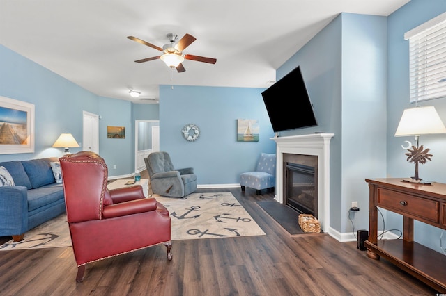 living room with baseboards, a fireplace with flush hearth, and wood finished floors