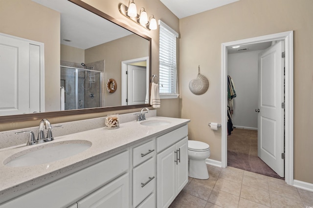 bathroom with tile patterned flooring, a stall shower, double vanity, and a sink