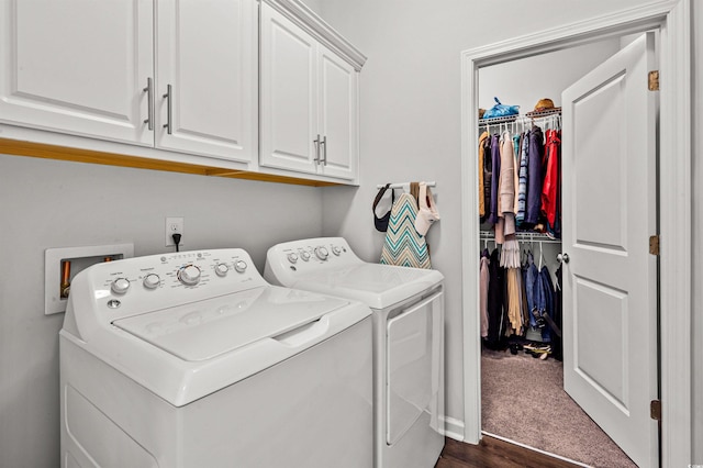 washroom featuring dark wood-style floors, cabinet space, and washing machine and dryer