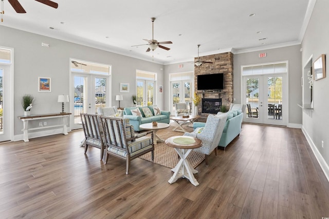 living area with ornamental molding, wood finished floors, french doors, a fireplace, and baseboards