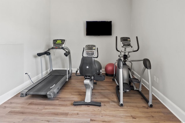 exercise area featuring light wood-style flooring and baseboards