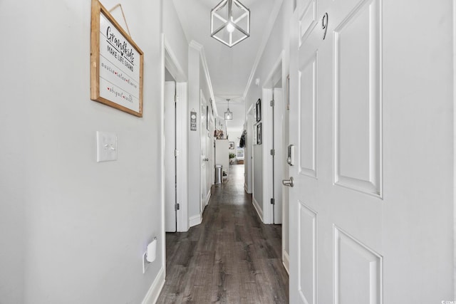 corridor with crown molding, dark wood-style floors, and baseboards