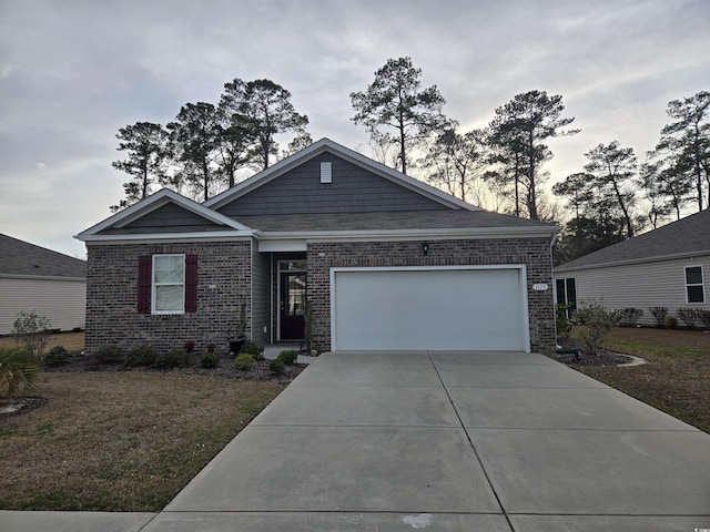 view of front of house featuring a front lawn, a garage, brick siding, and driveway