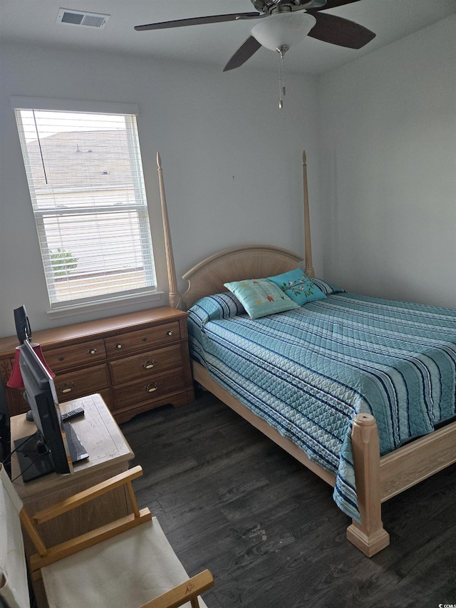 bedroom with ceiling fan, visible vents, and dark wood-style floors