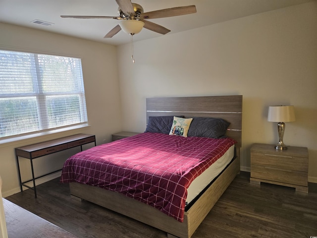 bedroom featuring visible vents, a ceiling fan, baseboards, and wood finished floors