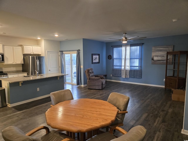 dining area featuring a ceiling fan, dark wood-style floors, and baseboards