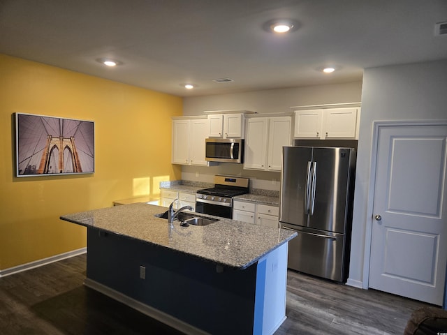 kitchen featuring stainless steel appliances, dark wood-type flooring, an island with sink, and white cabinets