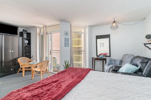 carpeted bedroom featuring a textured ceiling and access to outside