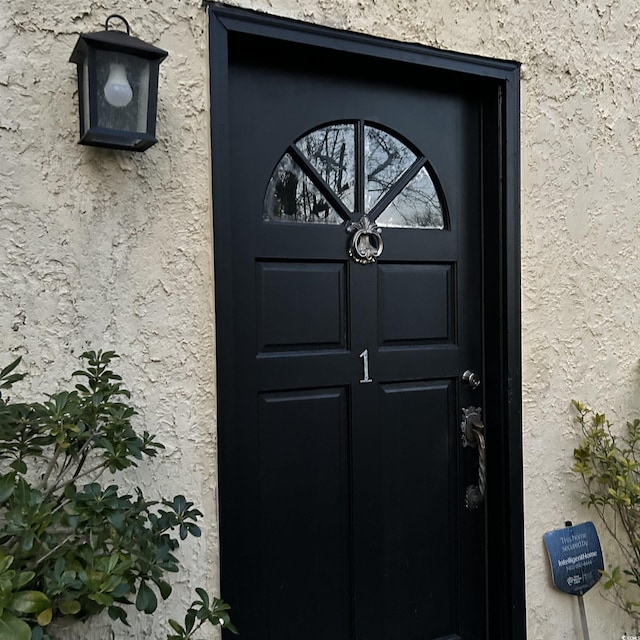 property entrance with stucco siding