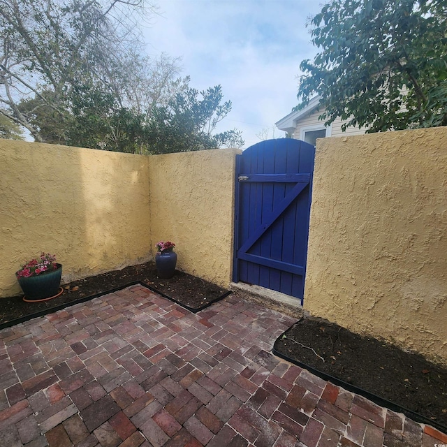 view of patio with fence and a gate