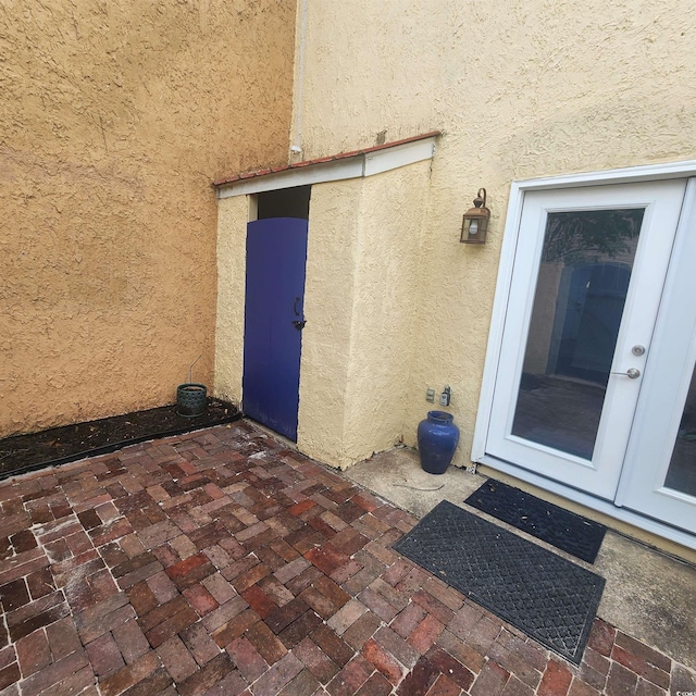 property entrance featuring stucco siding and a patio