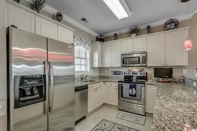 kitchen with visible vents, a sink, light stone counters, appliances with stainless steel finishes, and crown molding