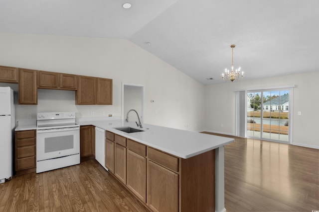 kitchen featuring a sink, dark wood finished floors, white appliances, a peninsula, and lofted ceiling