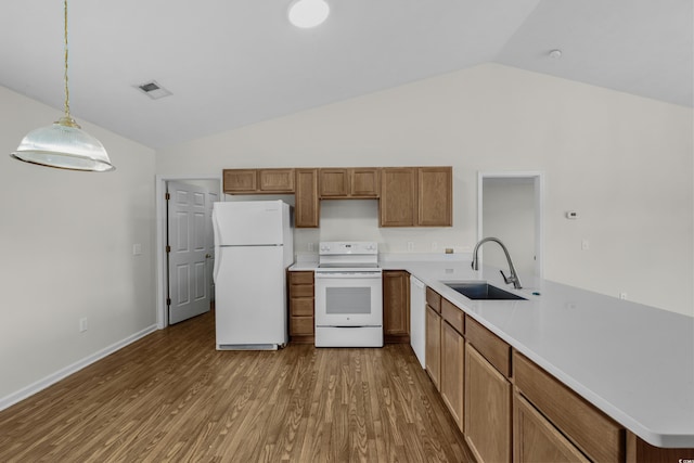 kitchen featuring white appliances, wood finished floors, visible vents, lofted ceiling, and a sink