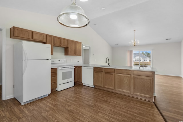 kitchen featuring white appliances, a peninsula, dark wood-style flooring, a sink, and light countertops