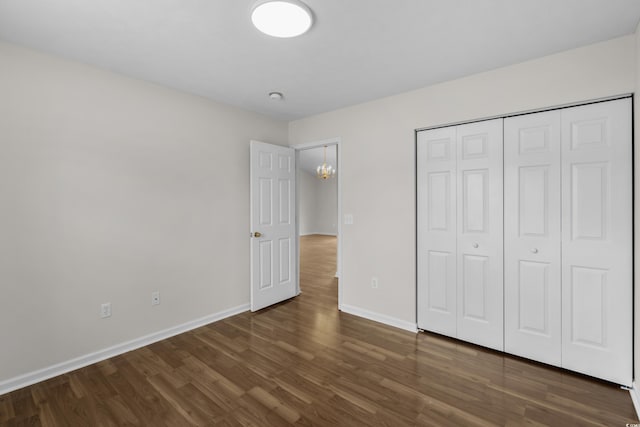 unfurnished bedroom featuring a closet, baseboards, and wood finished floors