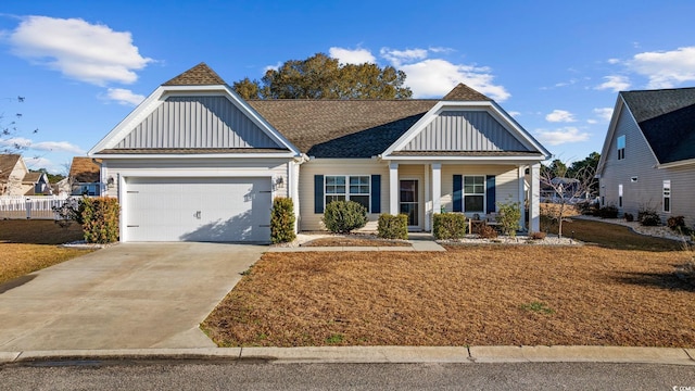 view of front of home with board and batten siding, an attached garage, driveway, and roof with shingles