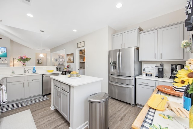 kitchen with a sink, light countertops, light wood finished floors, and stainless steel appliances