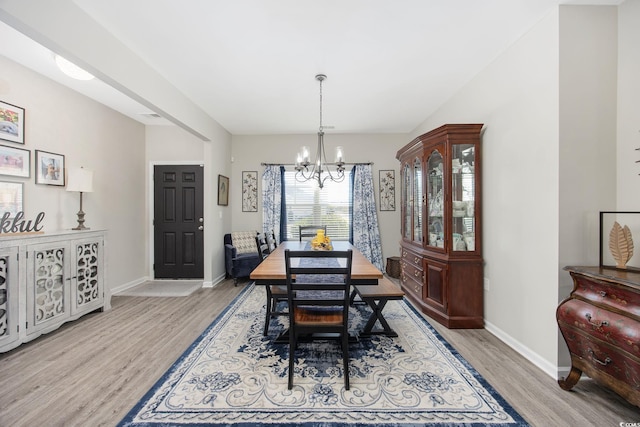 dining area with a notable chandelier, wood finished floors, and baseboards