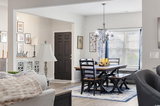 dining room with visible vents, baseboards, light wood-style floors, and an inviting chandelier