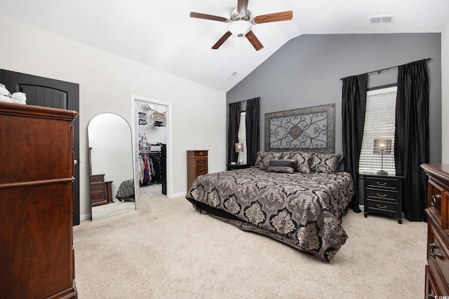 bedroom featuring light carpet, visible vents, a walk in closet, and lofted ceiling