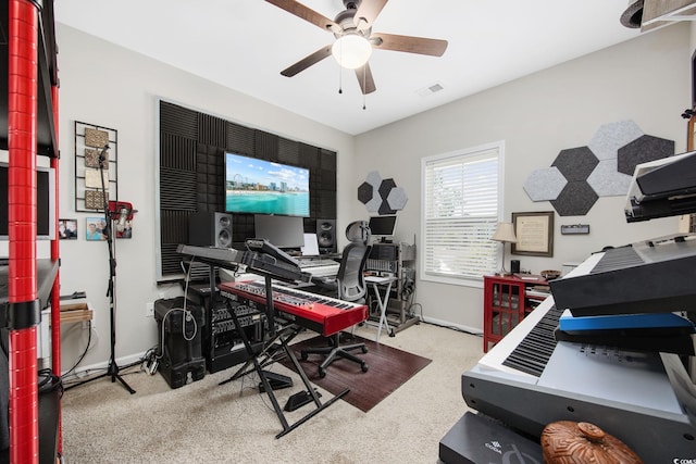 carpeted office space featuring a ceiling fan, visible vents, and baseboards