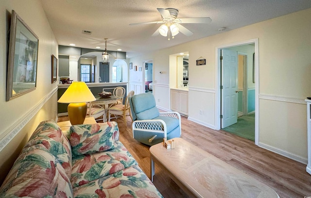 4430 Eastport Blvd Unit L9, Little River, SC 29566 - living room featuring arched walkways, a textured ceiling, a ceiling fan, wood finished floors, and visible vents