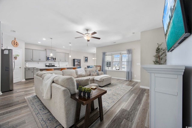 living area featuring visible vents, baseboards, ceiling fan, recessed lighting, and wood finished floors