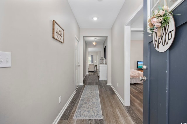 hall with baseboards and wood finished floors