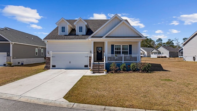 craftsman-style house with a porch, driveway, a front yard, and board and batten siding