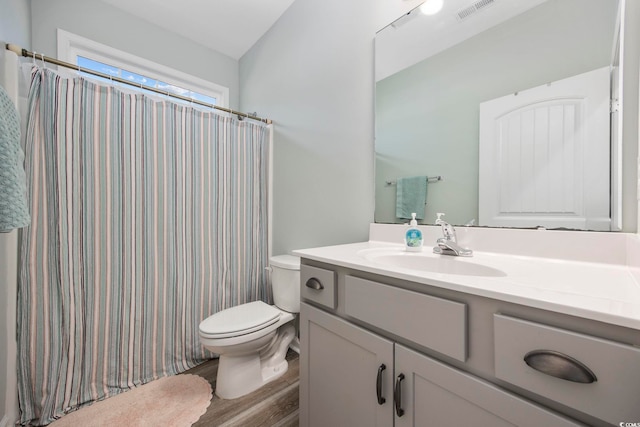 bathroom with vanity, a shower with curtain, wood finished floors, visible vents, and toilet