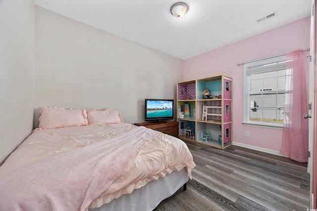 bedroom featuring visible vents, wood finished floors, and baseboards