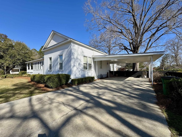 view of side of home with an attached carport and concrete driveway