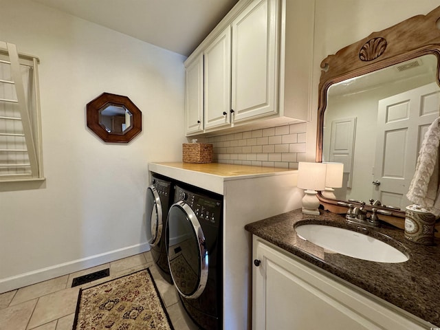 washroom featuring visible vents, baseboards, light tile patterned floors, independent washer and dryer, and a sink