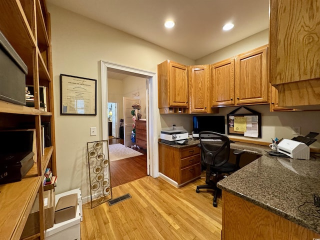 office space with visible vents, baseboards, light wood-style flooring, recessed lighting, and built in desk