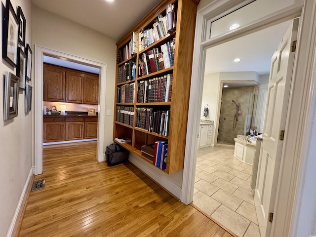 corridor featuring recessed lighting, visible vents, baseboards, and light wood-style flooring