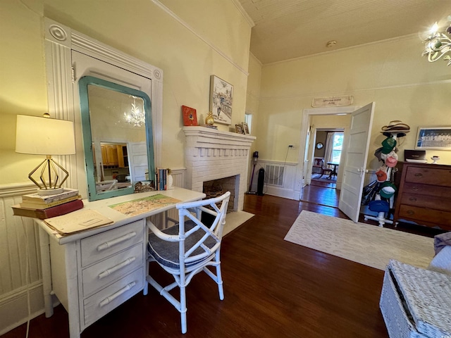 home office featuring a wainscoted wall, wood finished floors, crown molding, a decorative wall, and a brick fireplace