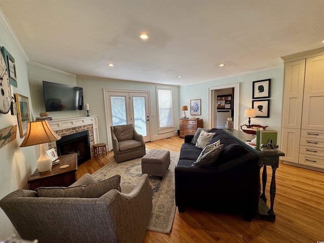 living room with recessed lighting, a fireplace, crown molding, and light wood-style floors