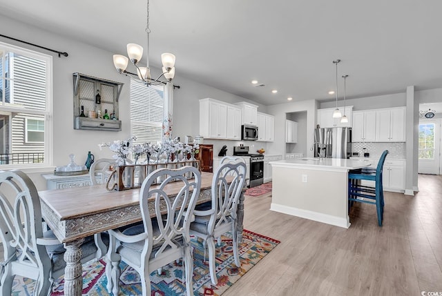 dining room featuring a notable chandelier, recessed lighting, and light wood-style floors