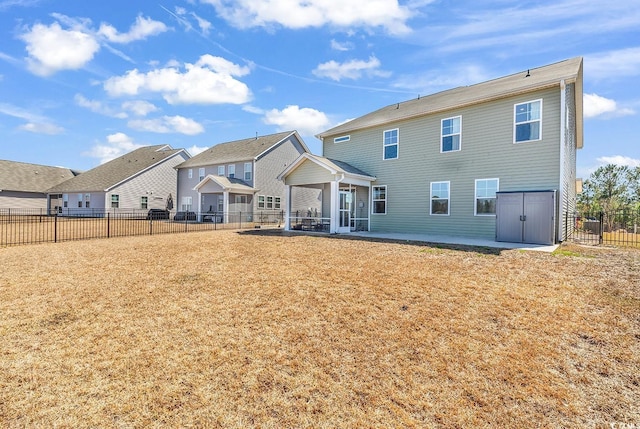 rear view of house with a residential view, fence, a lawn, and a patio area