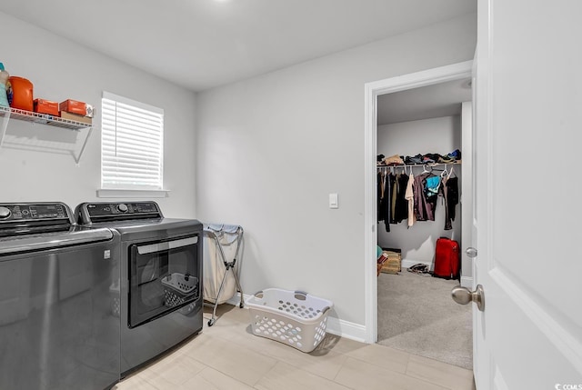 washroom featuring baseboards, light colored carpet, laundry area, and washing machine and clothes dryer