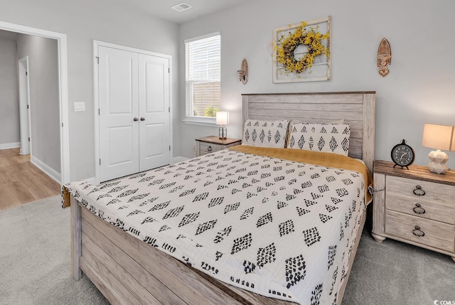 bedroom featuring visible vents, carpet, a closet, and baseboards