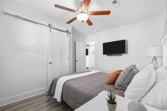 2406 Seabreeze Pl, Myrtle Beach, SC 29577 - bedroom featuring a barn door, wood finished floors, ceiling fan, and a closet